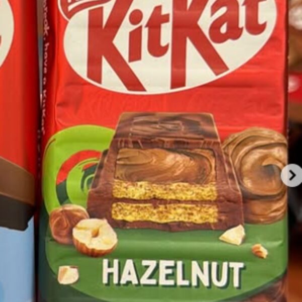Nestle KitKat Hazelnut bar in a red wrapper with a green band and hazelnuts pictured, imported from the United Kingdom